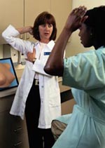 Fotografía de una médico enseñándole a su paciente como realizar el auto-examen del seno
