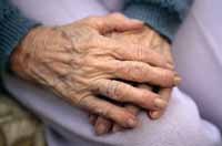 Fotografía de una mujer anciana que sufre de artritis en sus manos
