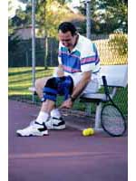 Fotografía de un hombre usando una venda especial para la rodilla, y jugando tenis