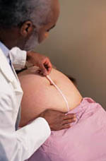 Fotografía de una persona tomando medidas en una visita prenatal