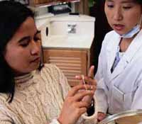 Picture of a young girl being instructed by her dentist on how to floss