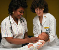 Picture of a newborn being examined by two nurses
