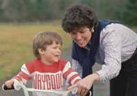 Picture of a mother teaching her son how to ride a bicycle