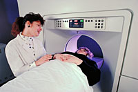 Picture of a technician talking with a patient in a CT scanner