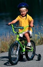 Fotografía de un niño pequeño que está montando bicicleta usando su casco