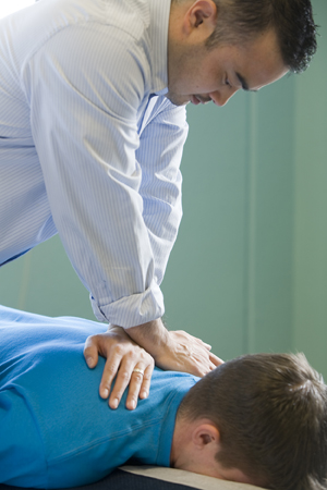 Massage therapist giving man a deep tissue massage.