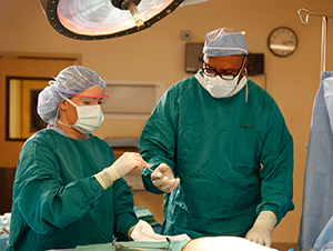 Healthcare providers performing surgery in operating room.
