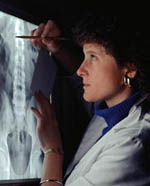 Fotografía de una radióloga leyendo una placa de rayos X
