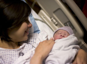Fotografía en primer plano de una nueva madre en una cama de hospital con su recién nacido